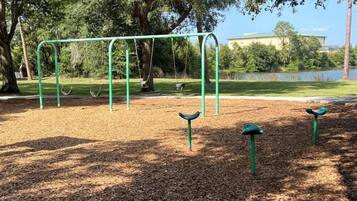 Um parque com baloiço e gangorra.