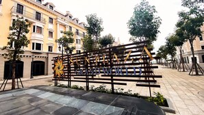 A sign for 'SUN PLAZA GRAND WORLD' with a decorative emblem, set in a courtyard with tiled flooring and trees. - Elysinam Boutique Hotel (Bai Chay)