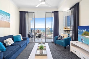 Enjoy ocean and city views from the balcony, featuring a dining area and comfortable seating.