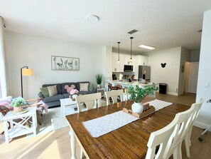 A modern kitchen with white cabinets, a central island, and pendant lighting.