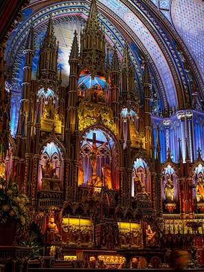 A Gothic-style cathedral interior with intricate stained glass windows and ornate architecture.