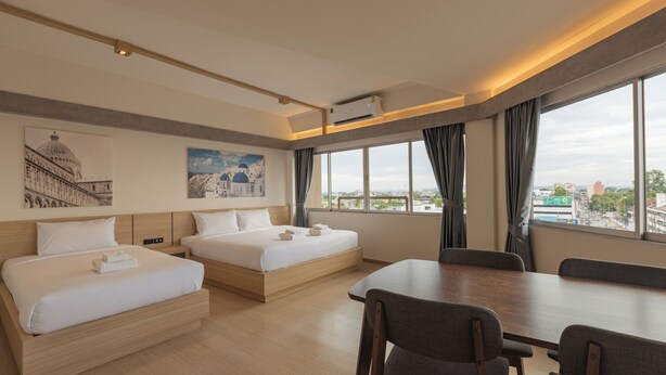 Une chambre d’hôtel avec deux lits, une table à manger et une vue sur la ville.