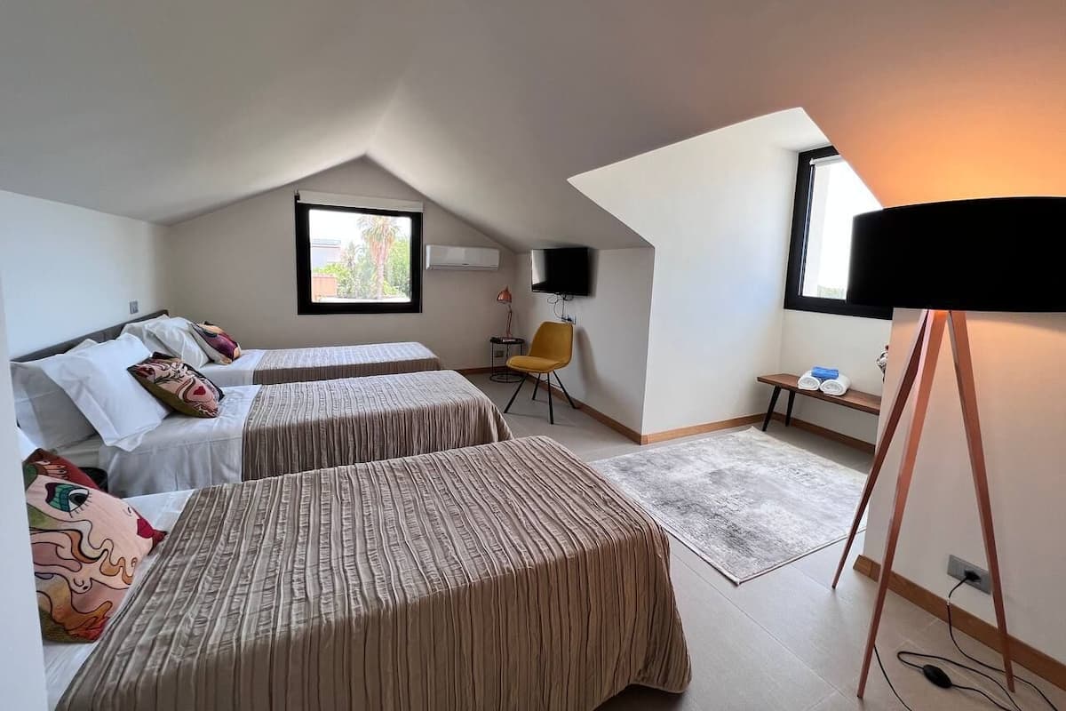 Ein Zimmer mit zwei Betten, einem Fernseher, einem Schreibtisch und einem Stuhl.