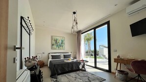 Un dormitorio moderno con una cama grande, un escritorio y vistas al exterior.