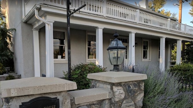 Una casa histórica con cimientos de piedra y un porche.