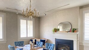 Un comedor con una mesa de madera dispuesta para seis personas, rodeada de seis sillas tapizadas.