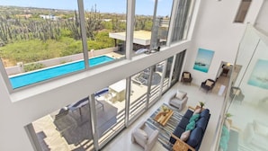 Un interno moderno con ampie finestre, una piscina e vista sul paesaggio circostante.
