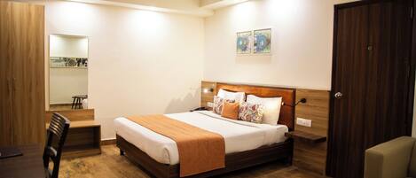A bedroom with a wooden bed, a desk, and a chair.