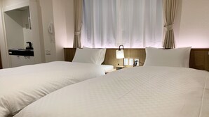A hotel room with two beds, a bedside table with a lamp, a phone, and a clock. - Waka Kyoto Kawaramachi (Kyoto)