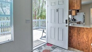 A kitchen with wooden cabinets, a white door, and a view of the outside. - Blue Mountainview welcomes long stays (Mariposa)