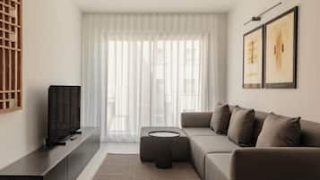 Deluxe-lejlighed - 2 soveværelser - balkon | Opholdsområde | 50-tommers smart-tv med digitale kanaler