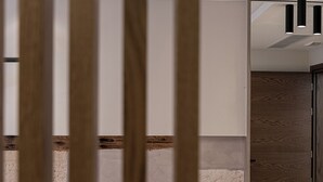 Ein modernes Badezimmer mit einer Holzhakepartition, einem Spiegel und einer Leuchte.