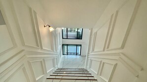 Eine Treppe mit weißen Wänden und Blick auf einen Balkon.