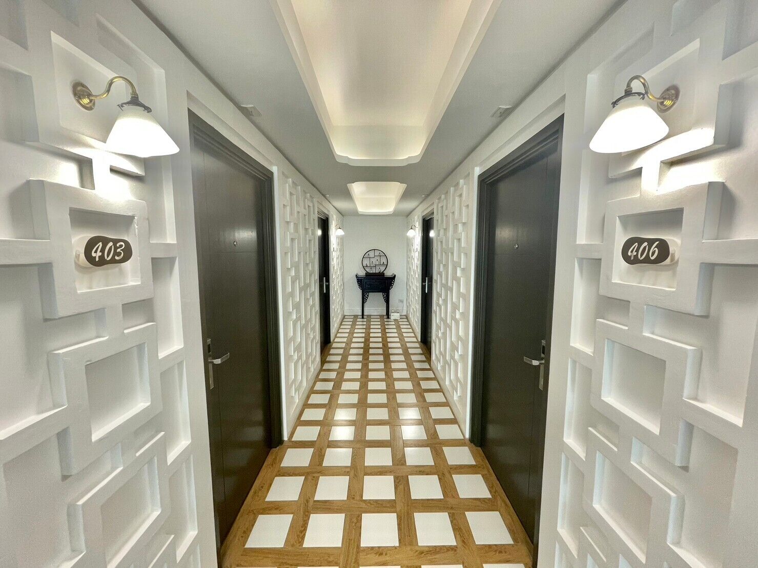 A hallway with a checkered floor pattern, white walls, and doors numbered 403 and 406.