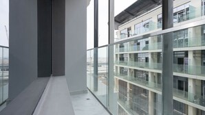 A modern building with large windows and a balcony. - Spacious Studio in Oasis 714 (Abu Dhabi)