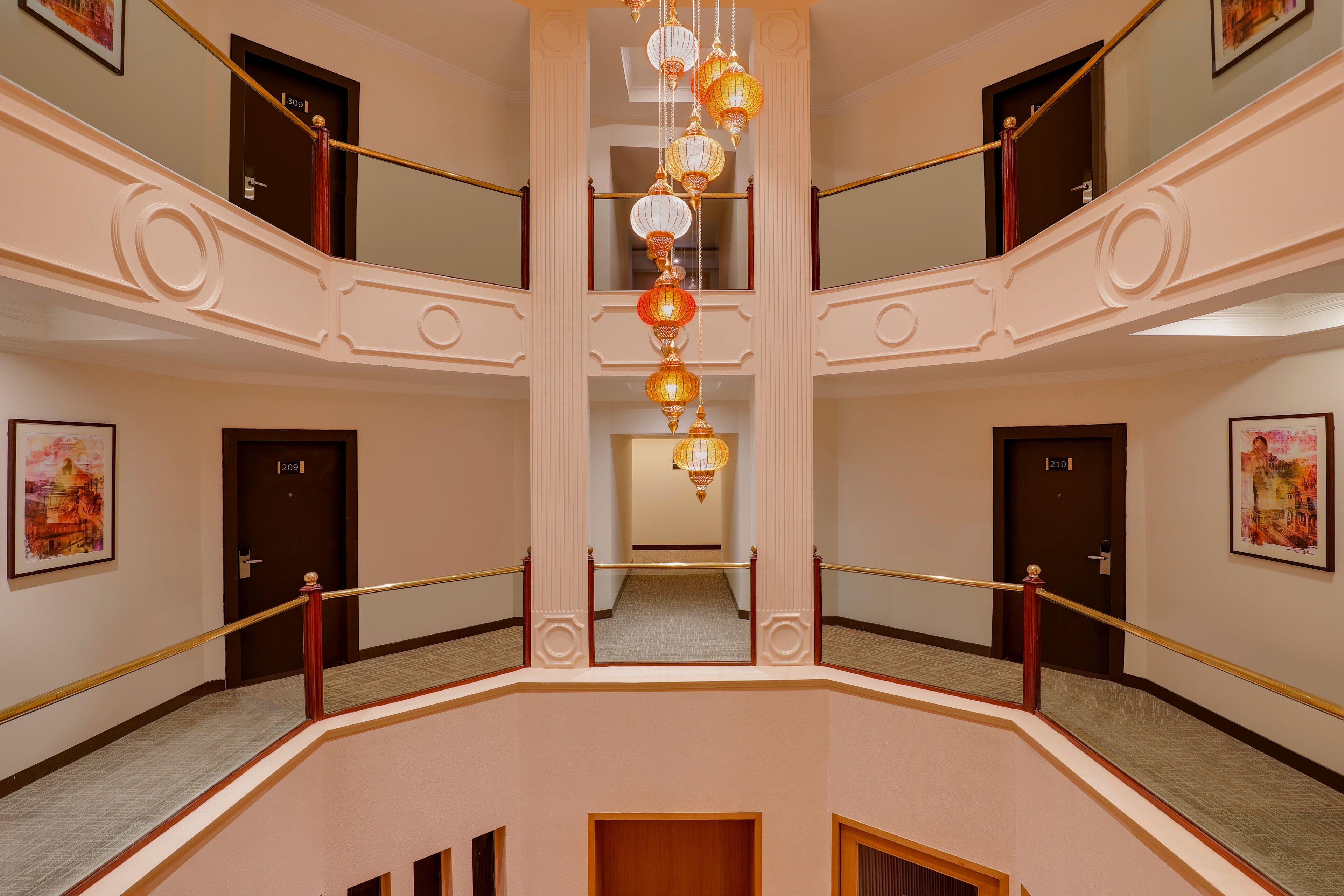 A multi-level interior with a central staircase, doors numbered 209 and 210, and hanging decorative lanterns.