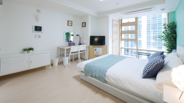 Une chambre à coucher moderne, avec un lit, un bureau et un téléviseur.