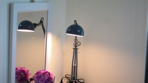 Un lampadaire doté d’un abat-jour réfléchissant et d’un miroir placé au-dessus.