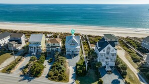 Un quartier résidentiel situé sur la côte, avec des maisons, une plage et une vue dégagée sur l’océan.
