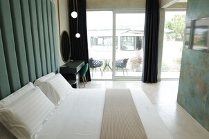 Habitación de hotel moderna con una cama grande, un escritorio y vistas del patio exterior.