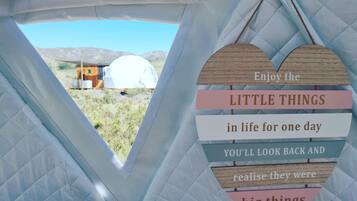 A view from inside a tent with a heart-shaped sign with motivational text.