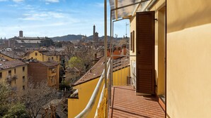 A balcony with a view of a cityscape, including buildings and a tower. - Irnerio Apartments by Wonderful Italy (Bologna)