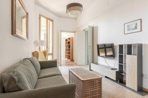 Ein modernes Wohnzimmer mit einer Couch, einem Fernseher und einem Bücherregal.