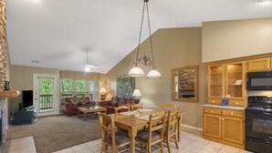 A spacious kitchen with a dining area, wooden cabinets, and a large window.