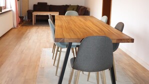 A dining area with a wooden table, grey chairs, and a wooden floor. - Vacation home Beulskopf - relaxing in nature (Heupelzen)