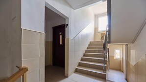 A staircase with a handrail, a door at the top, and a window at the bottom. - Compact Studio | Close to Park, Pet Friendly (Wroclaw)