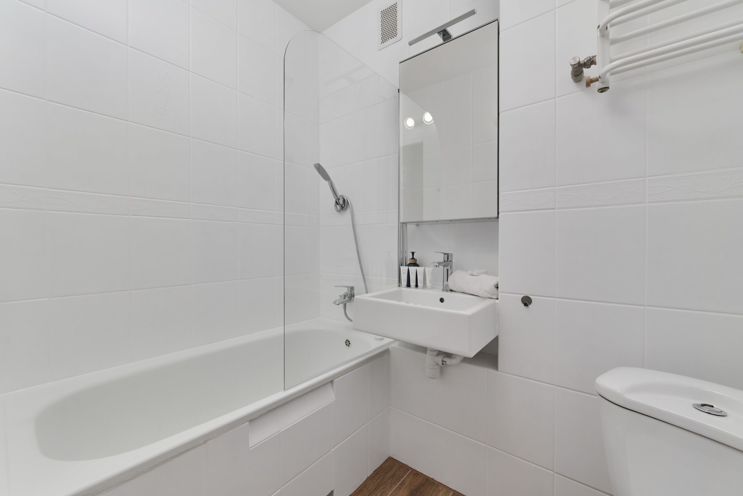 A modern bathroom with a bathtub, sink, and toilet.