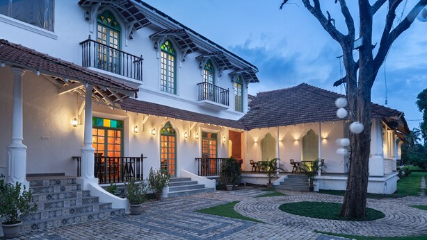 A two-story house with a porch, steps, and a garden. - Silva Heritage Resort Goa (Colva)
