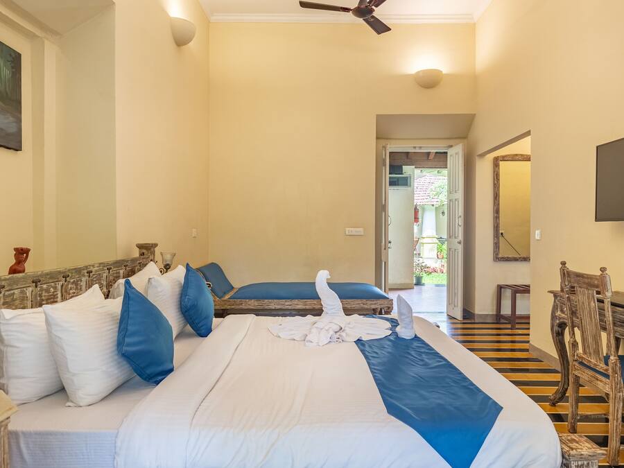 Habitación de hotel con una cama grande, cabecera de madera, escritorio con silla, televisión y un cuadro en la pared.