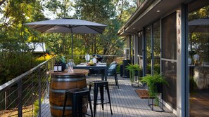 Relax in style on this outdoor patio, featuring a bar counter and comfortable seating under a shaded area.