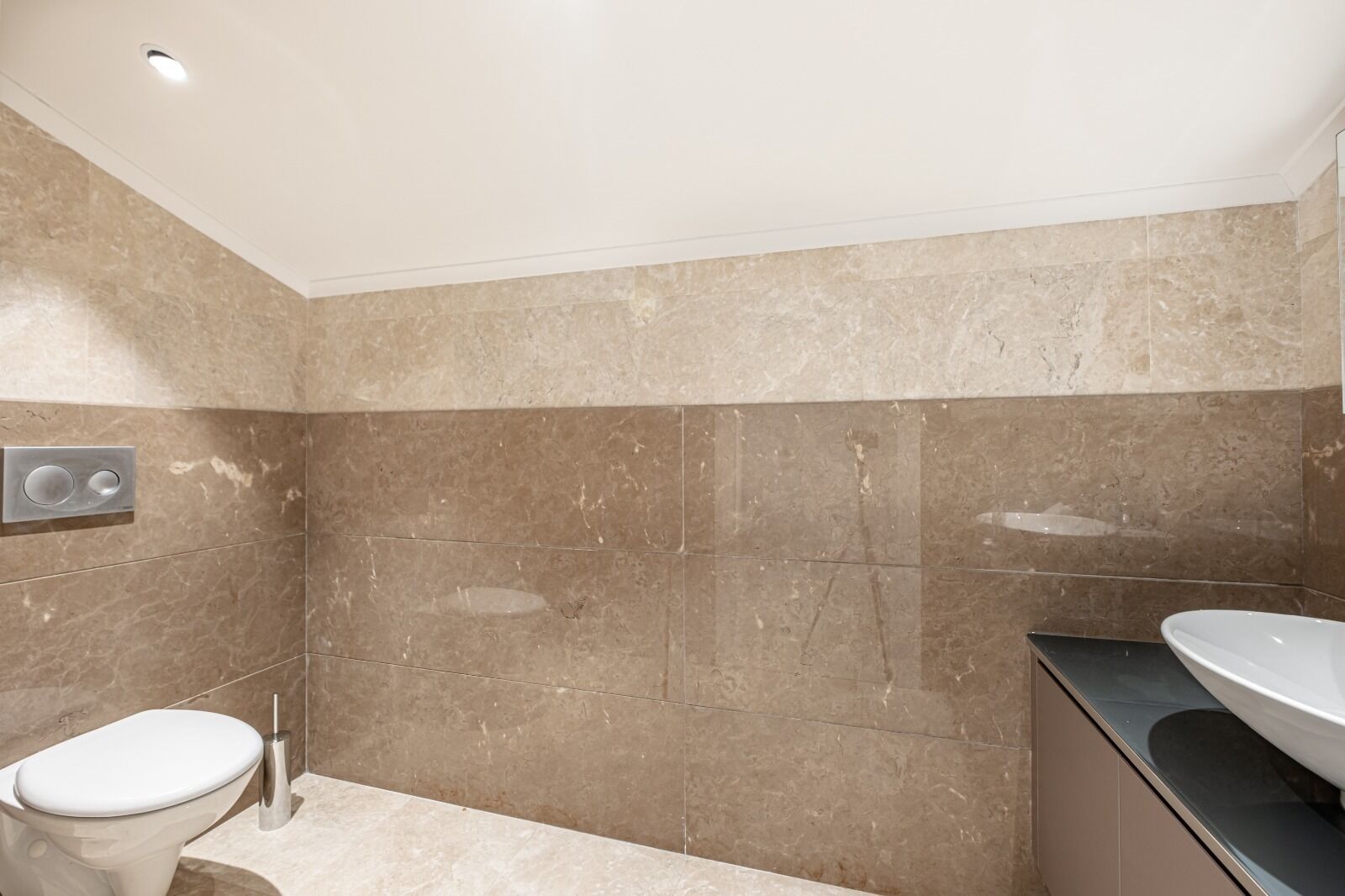 Un baño con inodoro, lavabo y zona de ducha.