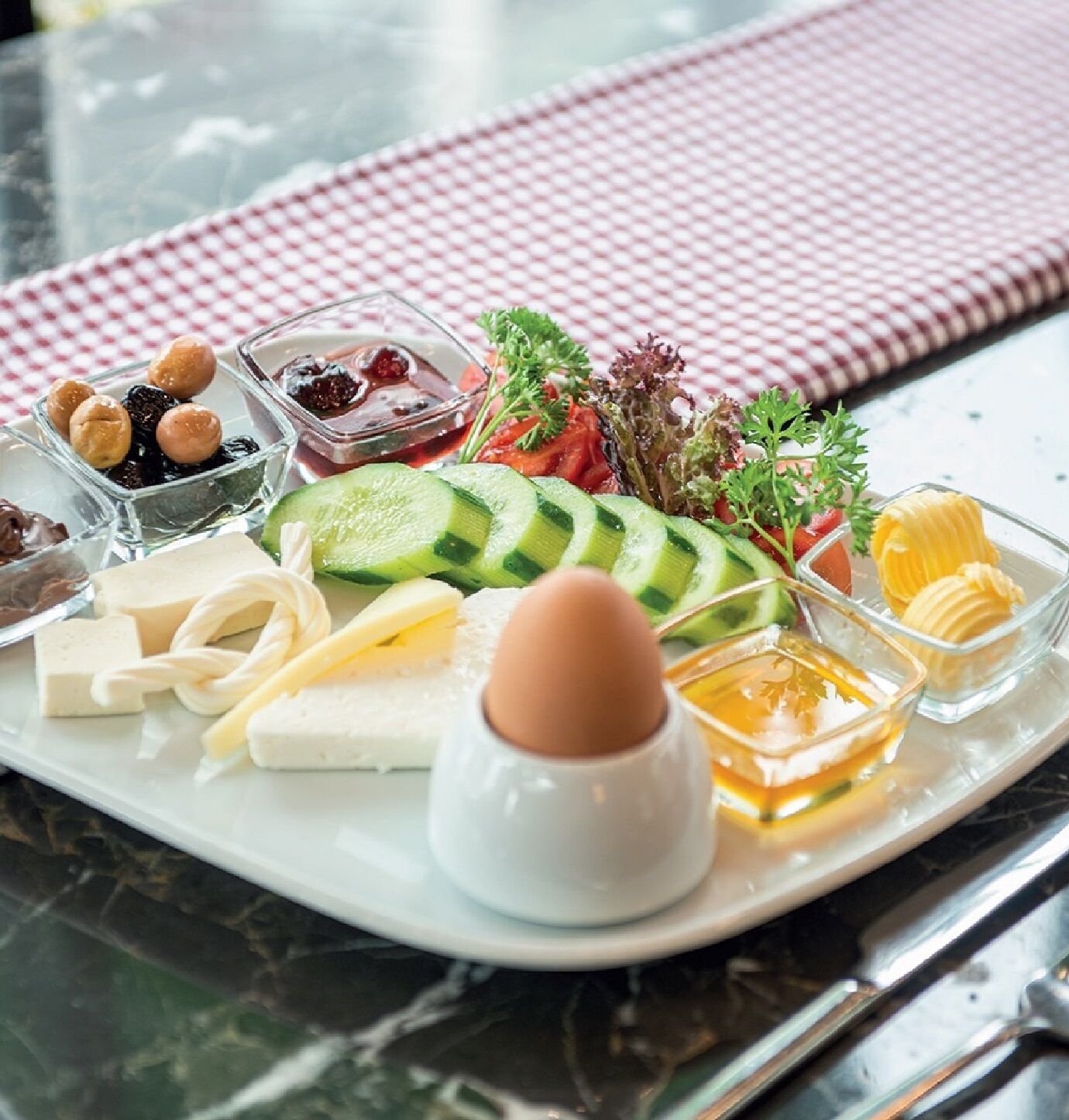 A breakfast tray with various foods including cheese, eggs, and vegetables.