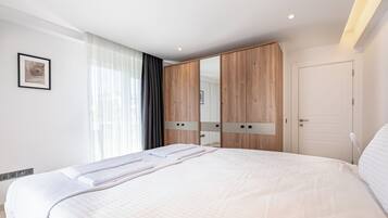 Een moderne hotelkamer met een groot bed, een garderobe met spiegels en een deur.