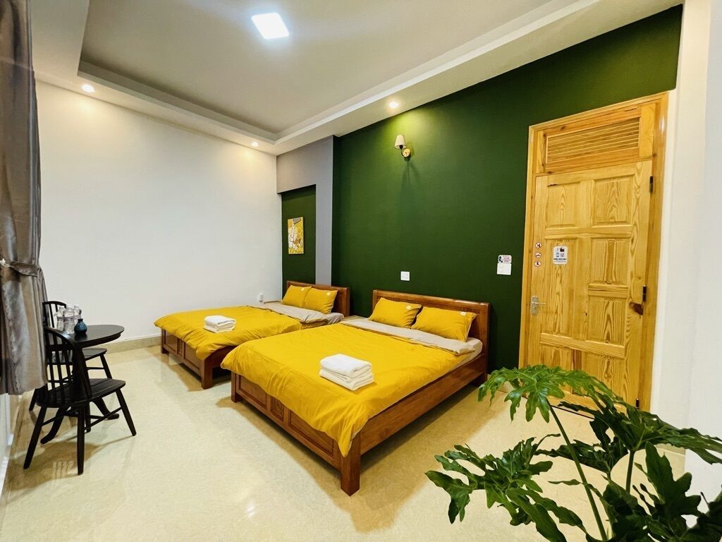 A room with two beds, a desk, and a chair.