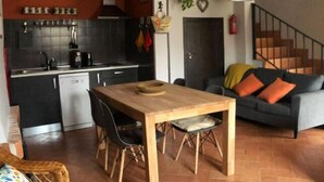 A compact living space with a kitchen, dining area, and a staircase.