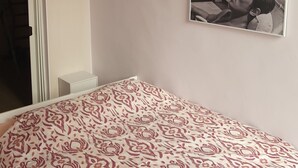 A bedroom with a bed, a wall-mounted picture, and a window. - OLD City in Style: Bright, Spacious & Comfortable (Nice)