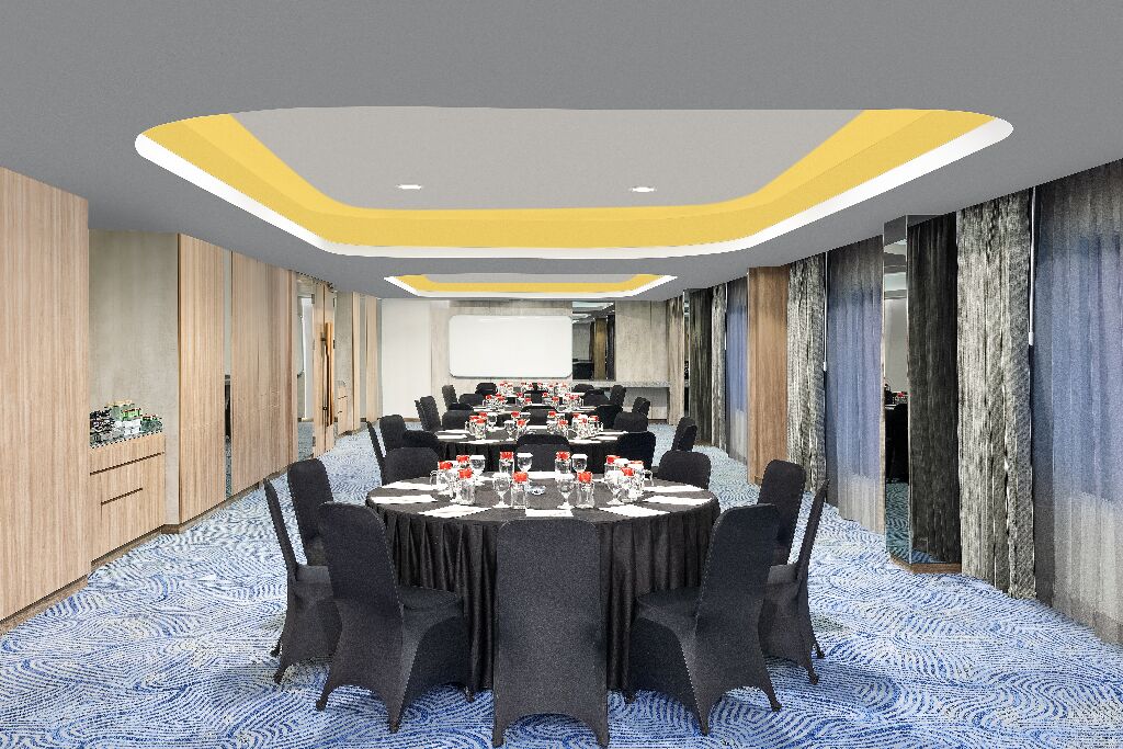 A conference room with a long table, chairs, and a presentation screen.