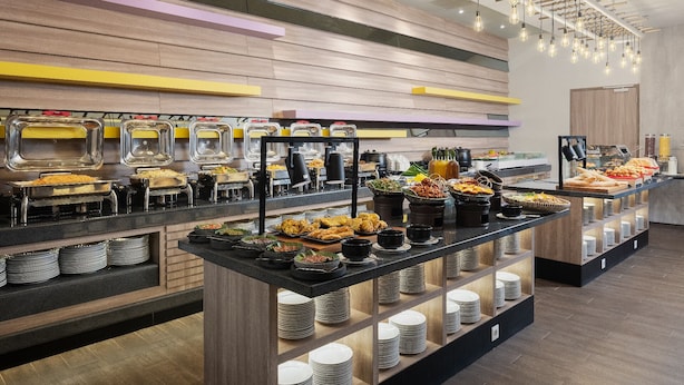 Montaje de bufé con varias estaciones de comida, incluyendo platos de arroz, ensaladas y frituras.