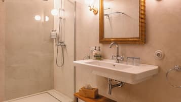 Un baño moderno con ducha, lavamanos y tocador.