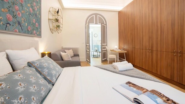 Una habitación de hotel moderna con una cama grande, un escritorio y un armario.