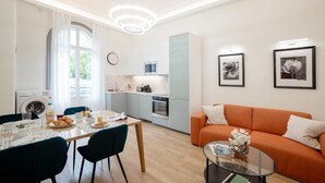 Una sala de estar moderna con comedor, cocina y lavadora.