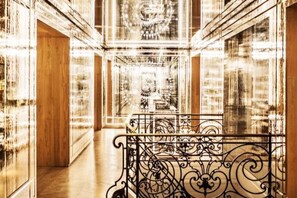 A grand hallway with ornate metal railings, a wooden floor, and a mirrored wall reflecting the ceiling's intricate design. - Secret House - Champs Élysée - Rare - AC (Paris)