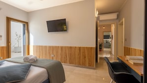 A modern hotel room with a bed, a desk, and a television. - Dimora Lauro (Gagliano del Capo)
