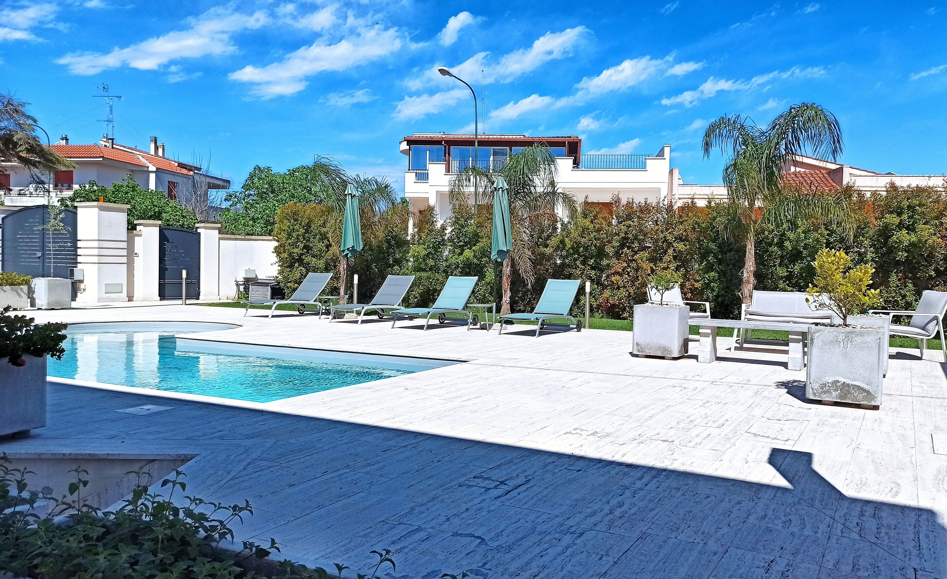 室外游泳池，池畔遮阳伞，日光浴躺椅