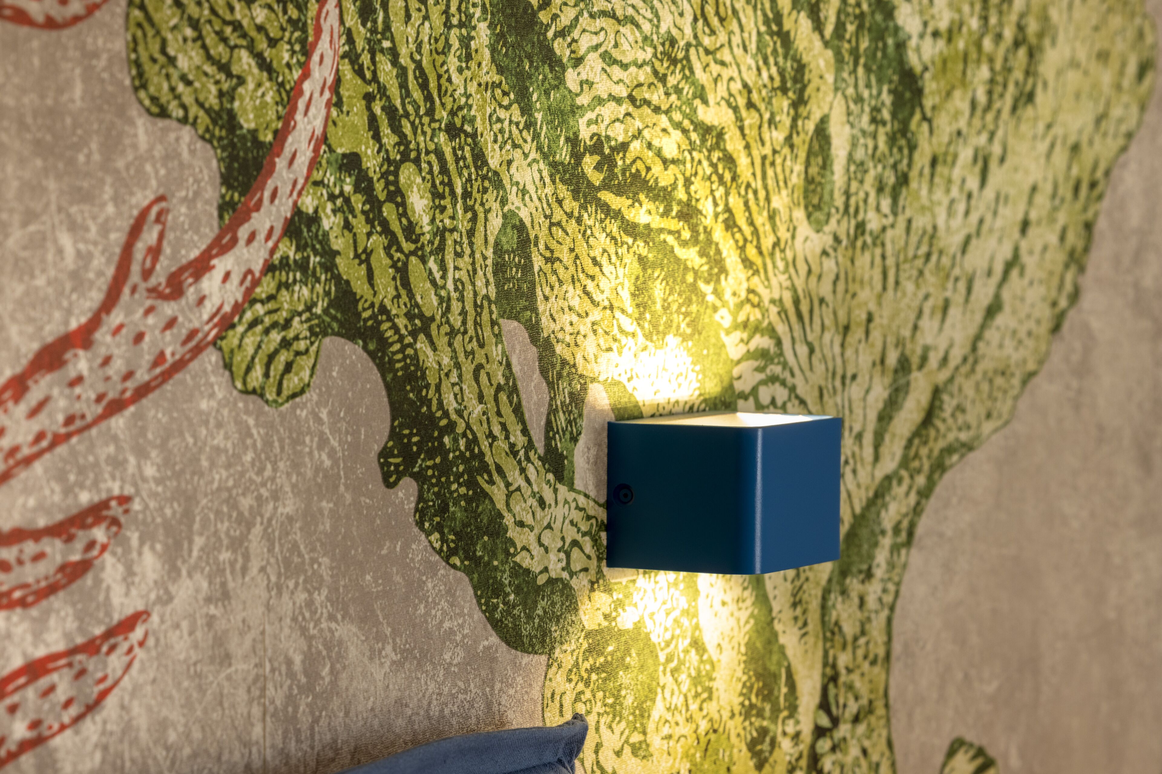 A wall with a textured pattern and a blue light fixture.