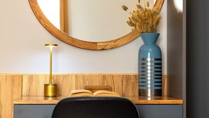 A wooden vanity with a mirror, a blue vase with dried flowers, a book, and a lamp. - Dimora Lauro (Gagliano del Capo)